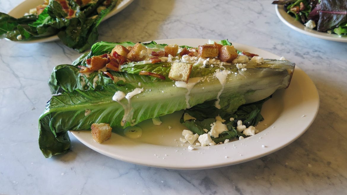 grilled romaine salad with bacon and feta cheese.