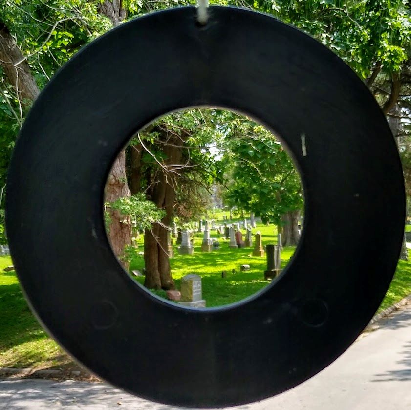 The center of windchimes that hang outside the office of the Union Cemetery Historical Society provide a frame for a view of the burial grounds.