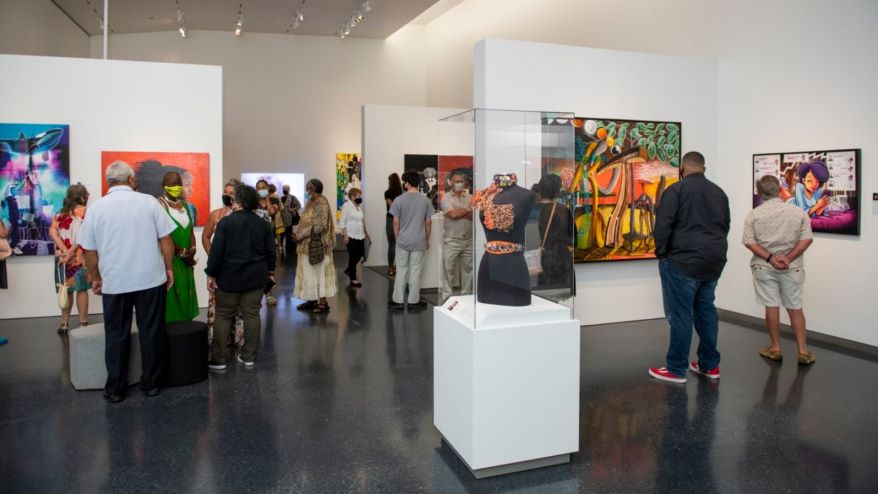 Visitors and artists gather in the “Testimony: African American Artists Collective” exhibit during a Collector’s Circle member evening in late July.