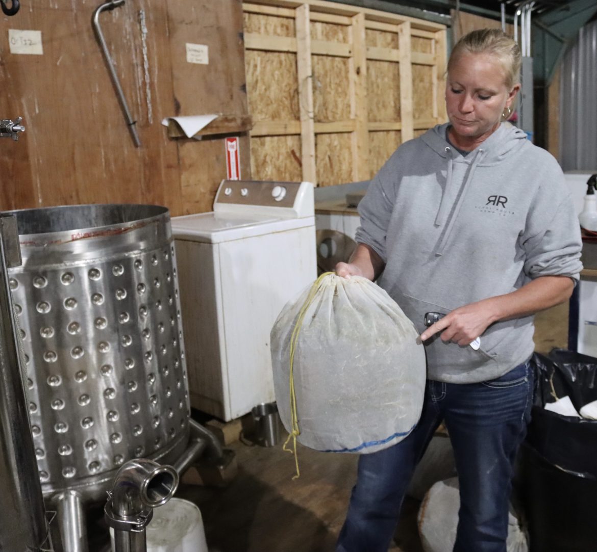 Michelle Poindexter prepares a bag of ground hemp to go into the silver agitator (left) which allows the cold ethanol to extract the cannabinoids from the biomass.