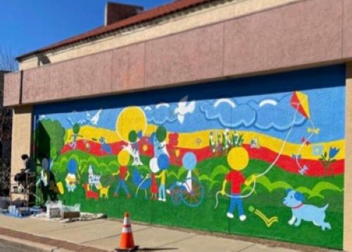 Taylar Sanders' mural on the exterior wall of Camp Bow Wow, a dog care services outlet, as part of the Westport/Wyandotte asphalt art project.