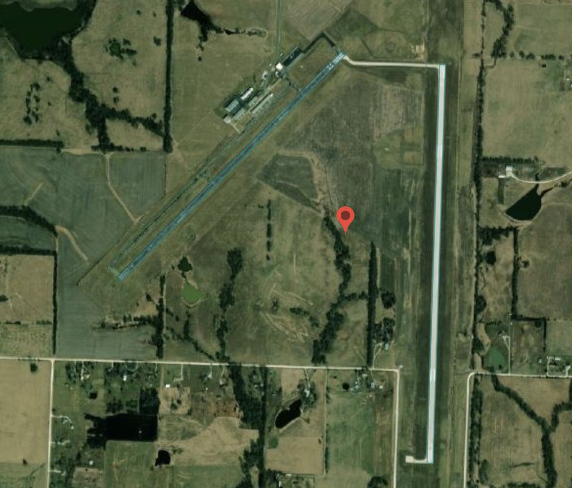 Arial photo shows two long runways amid green fields.