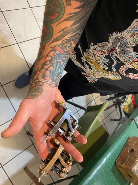 Artist Davey Gant shows off his tattoo machine. Machinery used by artists today are often hand-built modeling “old-school” instruments used by Bert Grimm.