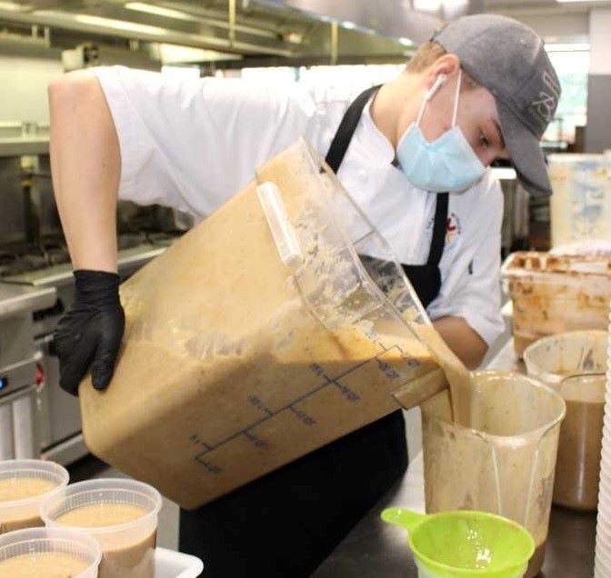 Noah Walls,17, pours gravy into quart containers.
