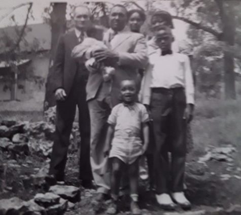 Herman Samuel Sears, Sr. (far left) and his wife, Almeda Pennington Sears (far right, back row) moved from Texas to Tulsa following the 1921 race massacre to help the community rebuild. In 1942 they joined other family members in Parkville, Missouri, for this family portrait, which included Frank Scott Douglass (holding his daughter Pearl) and his wife Lucille Sears Douglass, (to his left). Joining them was Charles Wesley Douglass, (front) son of Frank and Lucille, and Roscoe Turner, stepson of Lula Mae Turner, sister of Lucille.
