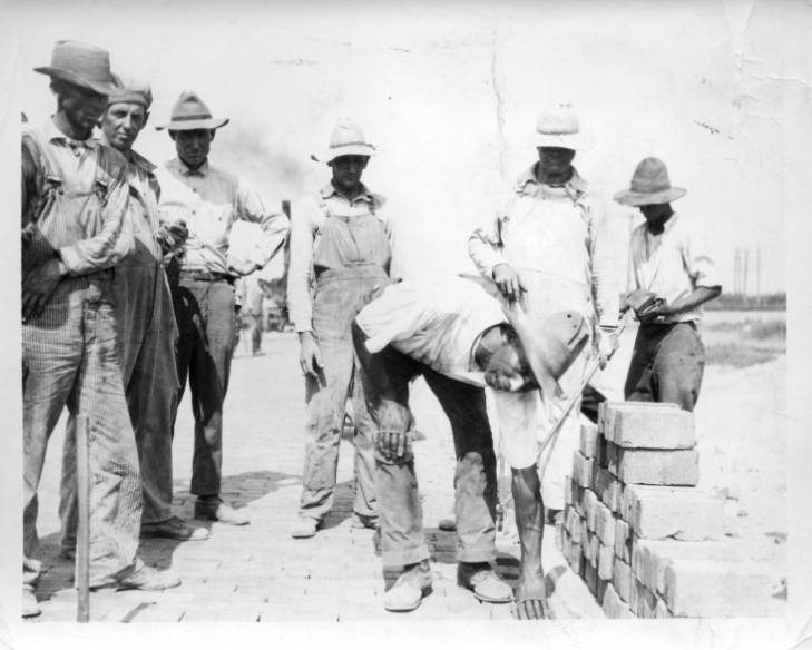 James Garfield Cleveland Brown lays bricks, surrounded by other brick road laborers. (Johnson County Museum) 