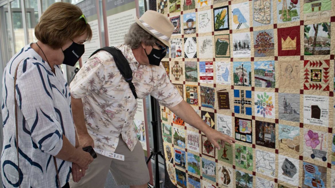 Steve and Calene Cooper identify blocks and stories shown in the Missouri Bicentennial Quilt.