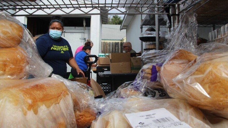 People check in to receive boxes of groceries at the Emmaus House food pantry. The number of meals served at Emmaus House nearly quadrupled between 2000 and 2010.